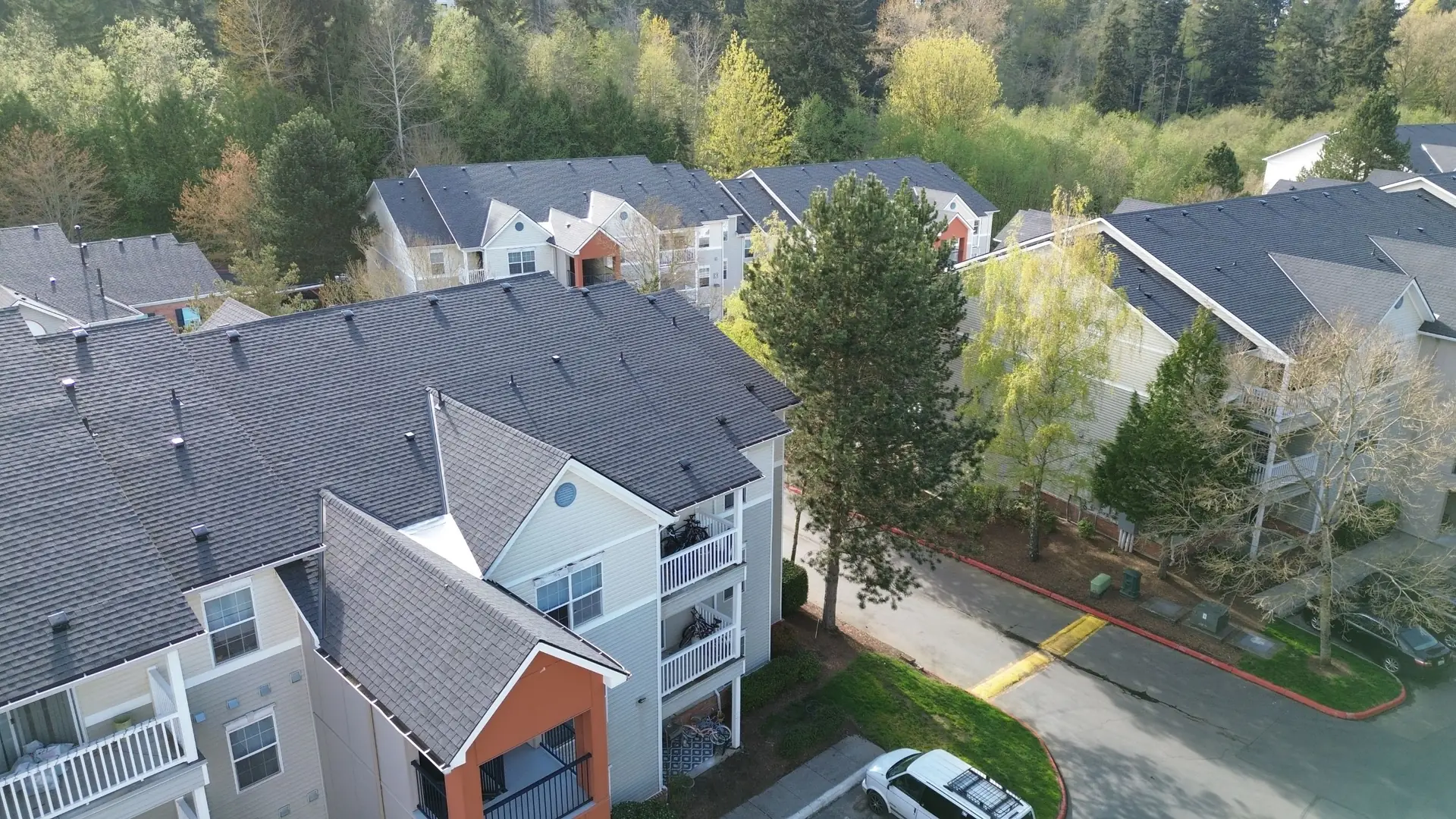 Aerial drone view of new asphalt shingle roofs on the Merrill Creek apartment community in Everett, Washington, installed by Amor Roofing