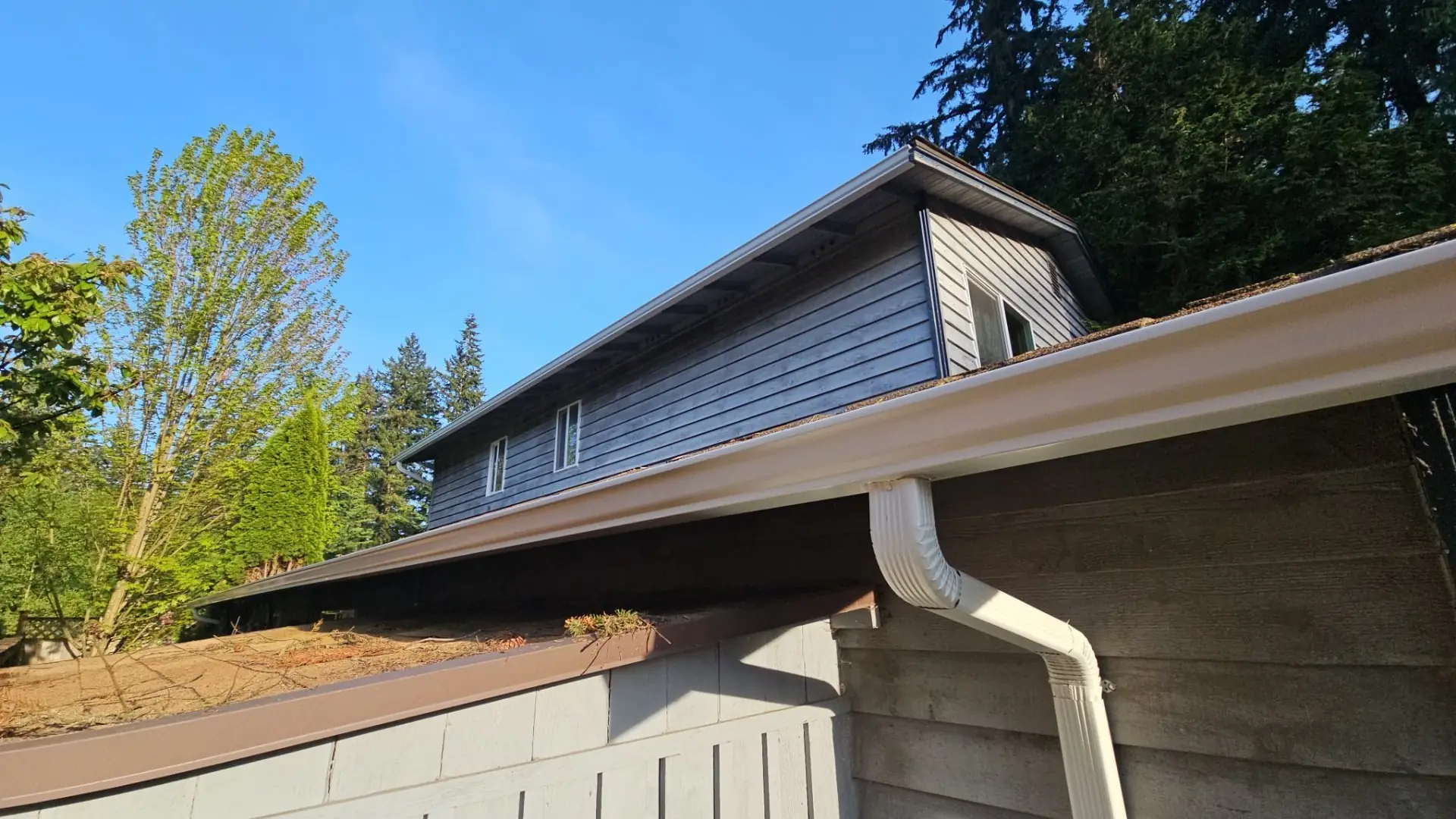 Seamless aluminum gutter run and downspout installed by Amor Roofing on a Marysville, Washington home